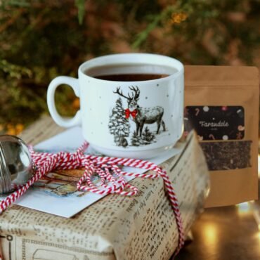 Sachet de tisane Farandole de Noël près d'une tasse et d'un paquet cadeau, ambiance de Noël